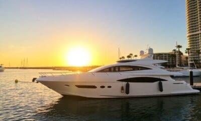 Luxusyacht liegt bei Sonnenuntergang in einem Yachthafen vor Anker.