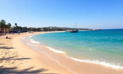 Sun-drenched Sitges beach with vibrant blue water.